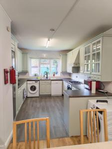 a kitchen with white cabinets and a sink at Standard Double Room with Shared Bathroom in London