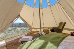 a tent with a bed and a chair in a room at Hraunborgir Golden Circle Tents in Kiðjaberg +109 photos