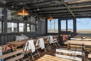 a restaurant with wooden tables and chairs and windows at Hraunborgir Golden Circle Tents in Kiðjaberg