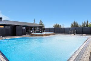 a large swimming pool in front of a house at Hraunborgir Golden Circle Tents in Kiðjaberg