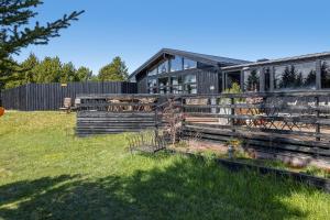 a house with a fence in the grass at Hraunborgir Golden Circle Tents in Kiðjaberg