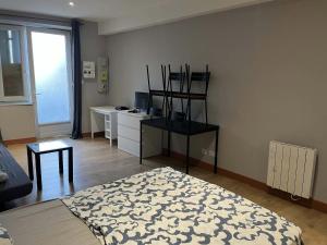 a room with a bed and a desk in it at studio in Saint-Pourçain-sur-Sioule
