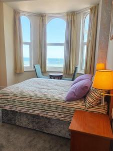 a bedroom with a bed with a view of the ocean at Downshire House in Douglas