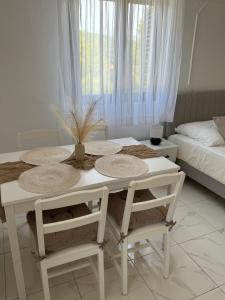 a white dining room table with two chairs and a bed at Apartments and Room Villa Makaj in Basina