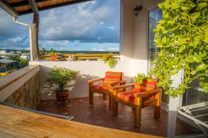 a balcony with two chairs and a table and a window at Hotel Cucuve in Puerto Ayora