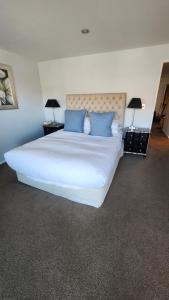 a bedroom with a large white bed with blue pillows at Luxury on Lakeside in Wanaka