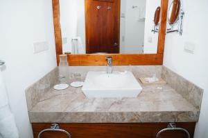 a bathroom with a sink and a mirror at Hotel Cucuve in Puerto Ayora +51 photos