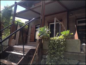 a house with some potted plants in front of it at Lo de Adriana in Tandil