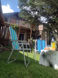 two chairs sitting in the grass in front of a house at Lo de Adriana in Tandil