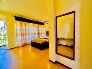 a mirror in a room with a bed and a bedroom at Villa Rustic in Negombo