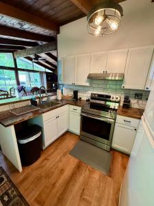 a kitchen with white cabinets and a sink and a stove at Cabin on the hill Ascutney in Jenneville +14 photos
