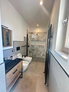 a bathroom with a toilet and a sink and a tub at Dorian Gray Luxury Suite in Trieste