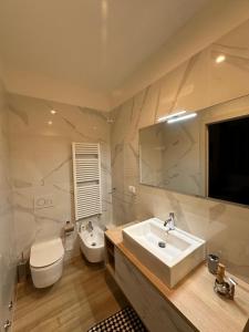a white bathroom with a sink and a toilet at Dorian Gray Luxury Suite in Trieste