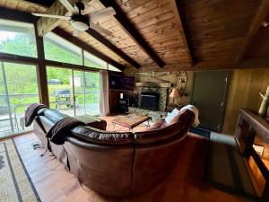 a large leather couch in a living room with a fireplace at Cabin on the hill Ascutney in Jenneville