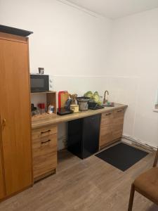 a kitchen with a desk with a sink and a microwave at Pokoje przy Żaglach in Rybnik +15 photos
