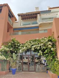 an entrance to a building with trees and tables at Slow Life Bouznika in Bouznika