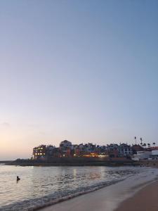a view of a beach with buildings in the distance at Slow Life Bouznika in Bouznika