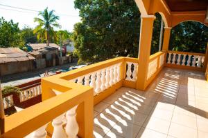 a balcony of a house with a yellow railing at Villa Domi in Antsiranana