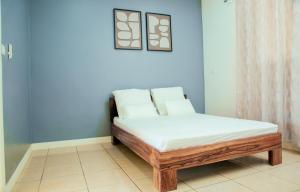 a bed in a room with a blue wall at Villa Domi in Antsiranana