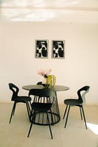 a dining room table with chairs and a vase on it at Villa Domi in Antsiranana