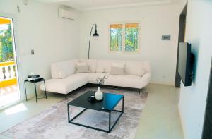 a living room with a white couch and a table at Villa Domi in Antsiranana