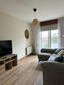 a living room with a couch and a flat screen tv at Casiña Carreiro in Beade