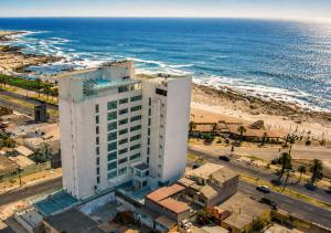a tall white building next to a beach at Alto del Sol Costanera Antofagasta in Antofagasta