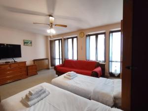 a living room with two beds and a red couch at Will House in Lanzo Torinese +3 photos