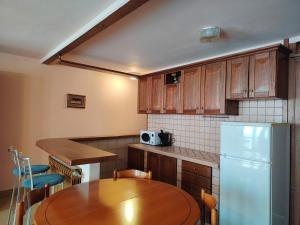 a kitchen with a wooden table and a refrigerator at Will House in Lanzo Torinese