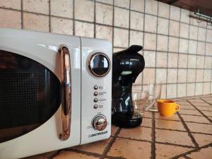 a microwave sitting on a counter next to a coffee maker at Will House in Lanzo Torinese