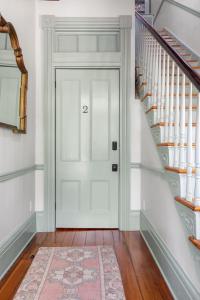 a hallway with a white door and a rug at Innkeepers Quarters Queen Suite with Breakfast in Charleston