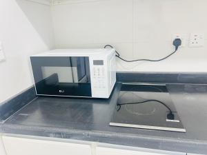 a microwave sitting on top of a kitchen counter at فـيليج سـانـسـت Village Sunset in Al Namas +22 photos