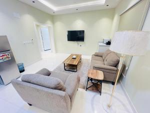 a living room with two couches and a table at فـيليج سـانـسـت Village Sunset in Al Namas