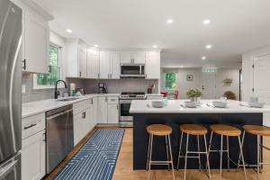 a kitchen with white cabinets and bar stools at Spacious Home with Private In-Ground Pool in Brewster