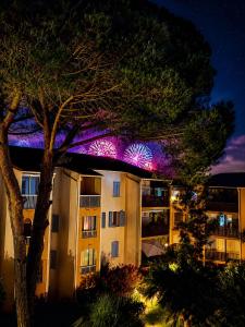 an apartment building with lights on the roof at night at Jacuzzi, massage et plage ! in Fréjus