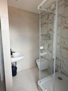 a bathroom with a glass shower and a sink at H&R Suite - Bielefeld Central in Bielefeld