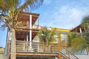 a building with a wooden staircase and palm trees at Villa Vichayito Relax in Vichayito