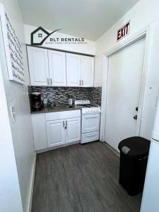 a small kitchen with white cabinets and a stove at Beautiful and Equipped Studio H in Hollywood