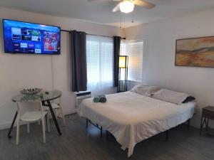 a bedroom with a bed and a table and a tv at Beautiful and Equipped Studio H in Hollywood