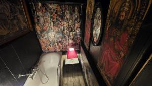 a small bathroom with a bath tub and a pink lamp at Legions Retreat in Antwerp +17 photos