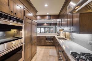 a kitchen with wooden cabinets and stainless steel appliances at Vail Ski-In Ski-Out Chalet in Vail