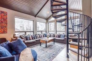 a living room with a couch and a spiral staircase at Vail Ski-In Ski-Out Chalet in Vail +37 photos