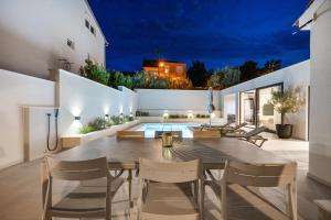 an outdoor dining room with a table and chairs at Villa Olea Mandalina in Šibenik
