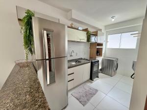 a kitchen with white cabinets and a refrigerator at Apto Com 2 Ar condicionados, Lava e seca, Wi-Fi in Caruaru