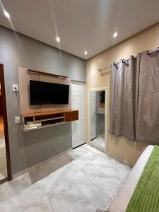 a living room with a flat screen tv on a wall at Pousada Mineira in Barreirinhas