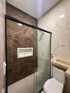 a bathroom with a glass shower with a toilet at Pousada Mineira in Barreirinhas +44 photos