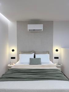 a bedroom with a large bed with white pillows at EROS & PATHOS Suites in Kremasti