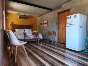a room with a refrigerator and a bedroom with a bed at Nelumbo Petit Chalet in San Rafael