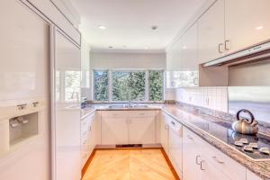 a kitchen with white cabinets and a large window at Ski-in Ski-Out the View in Vail in Vail