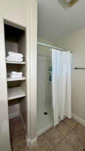 a walk in shower with a white shower curtain at Sabana in Lake Charles +30 photos
